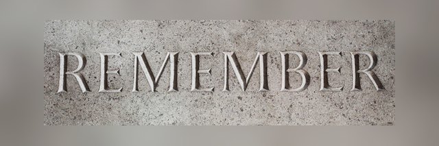 Remember gravé dans la pierre Mot "REMEMBER" gravé en lettres capitales dans une surface de pierre grise.